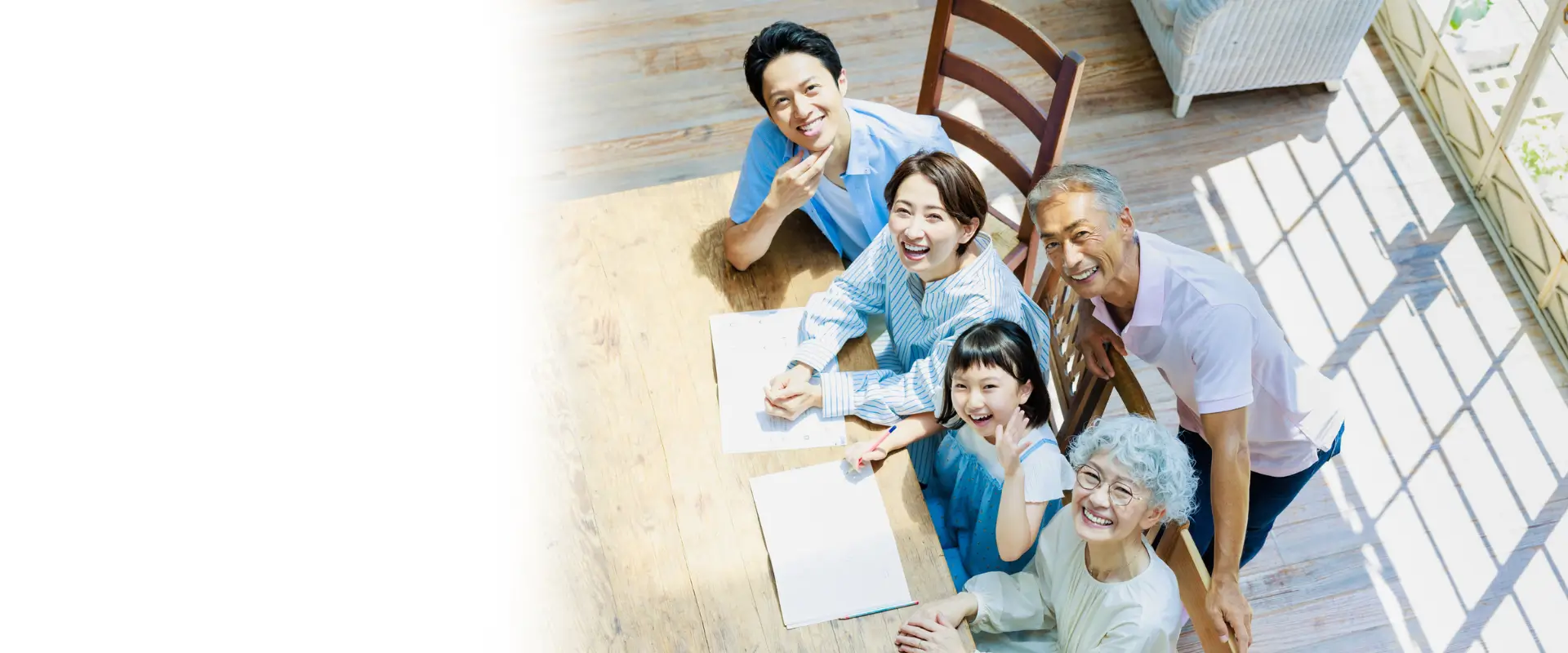 ダイニングテーブルで夫婦と子ども、祖父母が家族の家計について笑顔で話し合っている画像。オフィスアウジーテのコンセプトの１つ、「運勢のリズムに合わせてお金と暮らしを整える」という文言が添えられている。